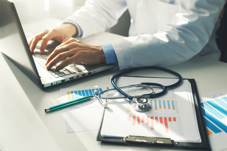 doctor working with medical statistics and financial reports in office